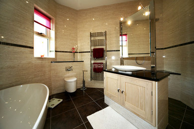 Contemporary wet room bathroom in Other with recessed-panel cabinets, a freestanding bath, a wall mounted toilet, beige tiles, ceramic tiles, ceramic flooring, a vessel sink, solid surface worktops, black floors, an open shower and black worktops.