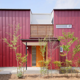 Réalisation d'une façade de maison rouge asiatique à un étage et de taille moyenne avec un toit à deux pans et un toit en métal.