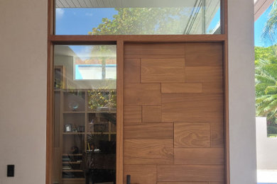 Immagine di una grande porta d'ingresso con una porta singola e una porta in legno bruno