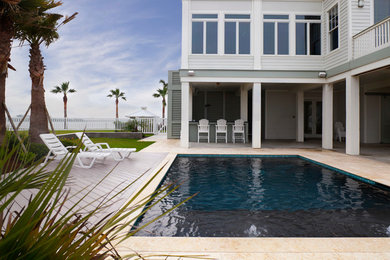 Mid-sized beach style backyard tile and rectangular pool photo in Houston