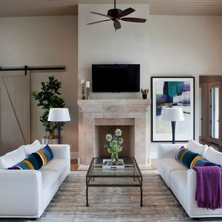 Idées déco pour une salle de séjour contemporaine ouverte avec un sol en bois brun, un manteau de cheminée en pierre, un téléviseur fixé au mur et un mur beige.