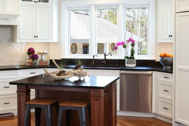 Inspiration for a large timeless u-shaped medium tone wood floor and brown floor eat-in kitchen remodel in Other with an undermount sink, recessed-panel cabinets, white cabinets, granite countertops, white backsplash, stone slab backsplash, stainless steel appliances and an island