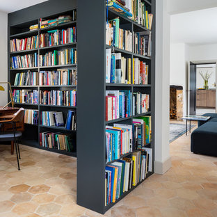 Inspiration for a contemporary home office in Gloucestershire with a library, terra-cotta floors, a freestanding desk and beige floor.