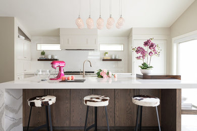 Transitional kitchen photo in Salt Lake City with shaker cabinets, beige cabinets, white backsplash, glass sheet backsplash and an island