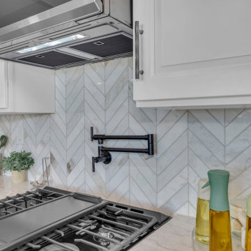 Elegant Chevron Tile Behind Stainless Cooktop in Contemporary Kitchen