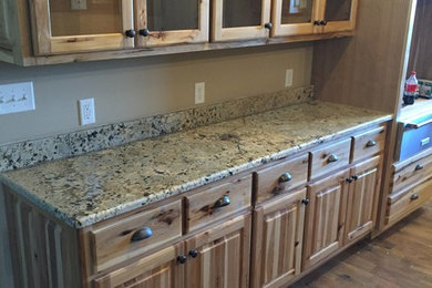 Inspiration for a large timeless dark wood floor and brown floor kitchen remodel in Nashville with raised-panel cabinets, medium tone wood cabinets, granite countertops, stainless steel appliances and an island