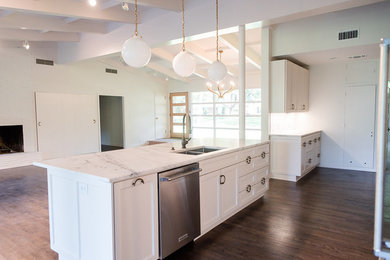Mid-sized 1960s u-shaped dark wood floor and brown floor open concept kitchen photo in Dallas with an undermount sink, shaker cabinets, white cabinets, marble countertops, white backsplash, marble backsplash, stainless steel appliances and an island