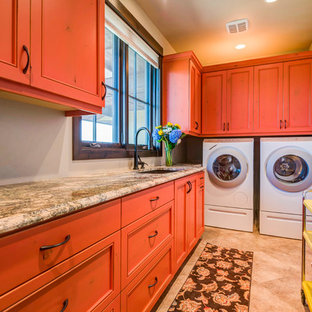 Foto de cuarto de lavado en L, de estilo americano, grande, con fregadero bajoencimera, armarios con rebordes decorativos, puertas de armario naranjas, encimera de granito, paredes beige, suelo de baldosas de cerámica, lavadora y secadora juntas, suelo beige y encimeras multicolor