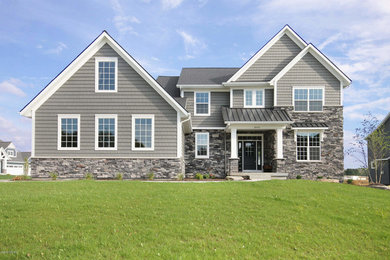 Example of a mid-sized transitional gray two-story mixed siding exterior home design in Grand Rapids with a shingle roof