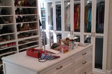 Inspiration for a large timeless gender-neutral light wood floor and brown floor walk-in closet remodel in Raleigh with recessed-panel cabinets and white cabinets