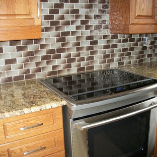 Mid-sized traditional kitchen pantry remodeling - Mid-sized elegant kitchen pantry photo in Toronto with light wood cabinets, granite countertops, raised-panel cabinets, multicolored backsplash, glass tile backsplash, stainless steel appliances and a double-bowl sink