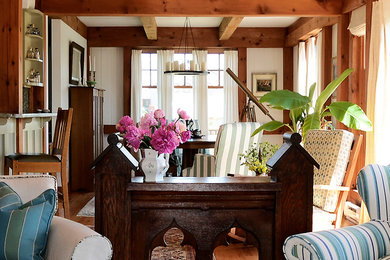 Example of a mid-sized eclectic open concept medium tone wood floor living room design in Providence with white walls and no fireplace