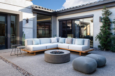 Example of a large trendy courtyard stone patio design in Las Vegas with a fire pit and no cover