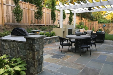 Photo of a mid-sized eclectic patio in DC Metro with natural stone pavers.