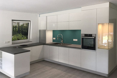 Offene, Mittelgroße Moderne Küche in U-Form mit Einbauwaschbecken, flächenbündigen Schrankfronten, weißen Schränken, Laminat-Arbeitsplatte, Küchenrückwand in Grün, Glasrückwand, Küchengeräten aus Edelstahl, Vinylboden, Halbinsel, grauem Boden und grauer Arbeitsplatte in Düsseldorf