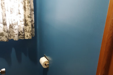 カンザスシティにある小さなトラディショナルスタイルのおしゃれなトイレ・洗面所 (一体型トイレ	、青いタイル、青い壁、クッションフロア、マルチカラーの床) の写真