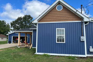 Imagen de fachada de casa azul y negra de estilo de casa de campo grande de dos plantas con revestimiento de vinilo, panel y listón y tejado de teja de madera
