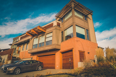 Example of a large transitional brown three-story wood house exterior design in Calgary