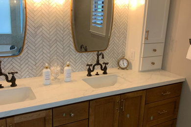 Example of a large minimalist master gray tile and matchstick tile mosaic tile floor and double-sink bathroom design in Seattle with shaker cabinets, medium tone wood cabinets, gray walls, an undermount sink, marble countertops, a hinged shower door, white countertops and a built-in vanity