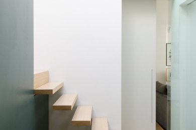 Design ideas for a contemporary wood floating staircase in London with wood risers.