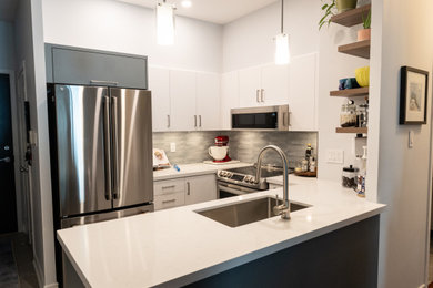 U-shaped ceramic tile and gray floor kitchen photo in Toronto with an undermount sink, flat-panel cabinets, white cabinets, quartz countertops, blue backsplash, porcelain backsplash, stainless steel appliances and white countertops