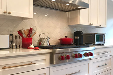 Photo of a mid-sized transitional kitchen in Dallas with shaker cabinets, white cabinets, quartz benchtops, white splashback, ceramic splashback, stainless steel appliances, with island and white benchtop.