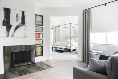 Photo of a large contemporary master bedroom in Los Angeles with white walls, a corner fireplace and a tile fireplace surround.