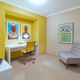 This is an example of a medium sized modern study in Sydney with yellow walls, carpet, no fireplace and a freestanding desk.