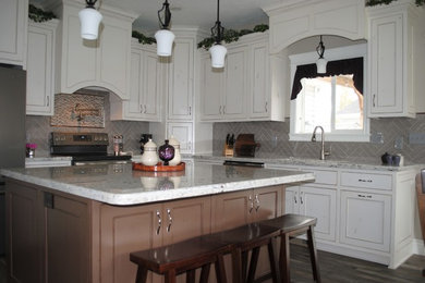 Example of a mid-sized classic l-shaped dark wood floor and gray floor open concept kitchen design in Other with an undermount sink, recessed-panel cabinets, white cabinets, granite countertops, gray backsplash, porcelain backsplash, stainless steel appliances, an island and gray countertops