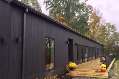 Mid-sized transitional black one-story wood exterior home photo in New York