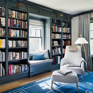 Foto på ett stort maritimt arbetsrum, med ett bibliotek, gula väggar, ljust trägolv, ett fristående skrivbord och blått golv