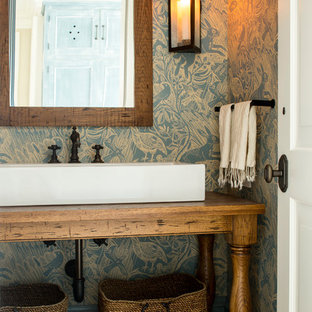 ニューヨークのトラディショナルスタイルのおしゃれなトイレ・洗面所 (家具調キャビネット、中間色木目調キャビネット、マルチカラーの壁、ベッセル式洗面器、木製洗面台、ブラウンの洗面カウンター) の写真