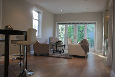 Inspiration for a mid-sized contemporary formal and open concept light wood floor living room remodel in Ottawa with beige walls, no fireplace and a wall-mounted tv