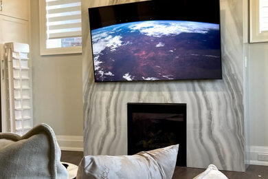 Imagen de cine en casa cerrado minimalista grande con suelo de madera oscura, televisor colgado en la pared y suelo marrón