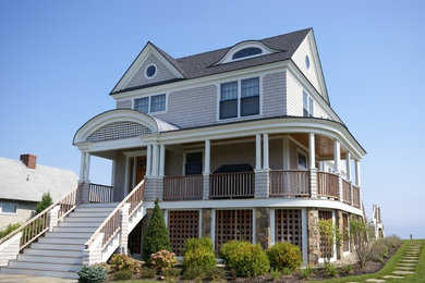 Photo of a mid-sized beach style two-storey grey exterior in Boston with wood siding and a gable roof.