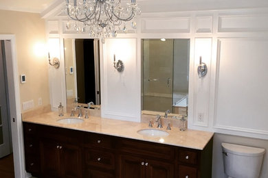 Example of a mid-sized classic master corner shower design in New York with an undermount sink, recessed-panel cabinets, dark wood cabinets, an undermount tub, a one-piece toilet and beige walls