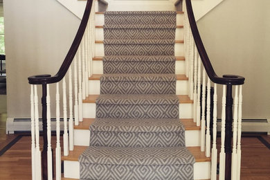 Carpeted curved staircase photo in Manchester with carpeted risers