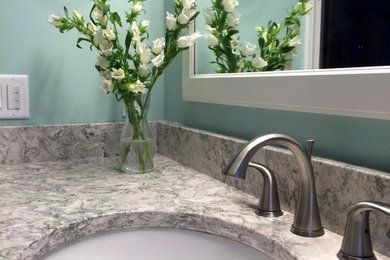 Alcove bathtub - mid-sized traditional kids' white tile and glass tile porcelain tile alcove bathtub idea in Bridgeport with raised-panel cabinets, white cabinets, a two-piece toilet, green walls, an undermount sink and quartzite countertops