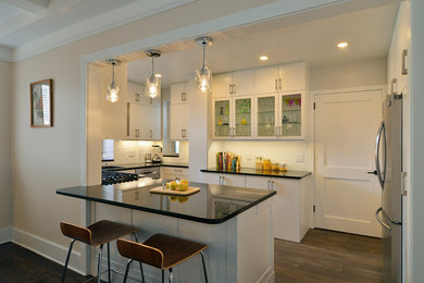 Eat-in kitchen - mid-sized contemporary u-shaped porcelain tile eat-in kitchen idea in New York with a single-bowl sink, flat-panel cabinets, white cabinets, granite countertops, white backsplash, ceramic backsplash, stainless steel appliances and a peninsula
