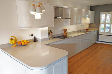 Inspiration for a medium sized contemporary galley kitchen/diner in Devon with quartz worktops, grey splashback, stainless steel appliances and grey worktops.
