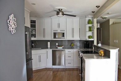 Open concept kitchen - mid-sized contemporary u-shaped light wood floor open concept kitchen idea in Other with an undermount sink, shaker cabinets, white cabinets, quartz countertops, gray backsplash, glass tile backsplash, stainless steel appliances and a peninsula