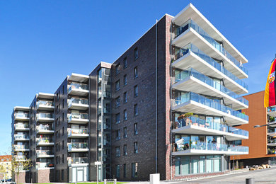 Dreistöckiges Modernes Haus mit Backsteinfassade und roter Fassadenfarbe in Sonstige