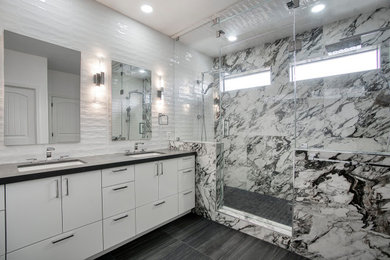 Exempel på ett stort modernt svart svart en-suite badrum, med släta luckor, vita skåp, en dubbeldusch, en bidé, svart och vit kakel, porslinskakel, vita väggar, klinkergolv i porslin, ett undermonterad handfat, granitbänkskiva, svart golv och dusch med gångjärnsdörr
