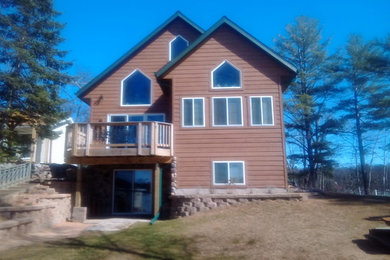 Example of a mid-sized arts and crafts brown three-story wood gable roof design in Other
