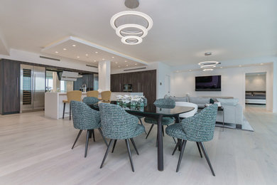 Large trendy light wood floor and beige floor dining room photo in Miami with white walls