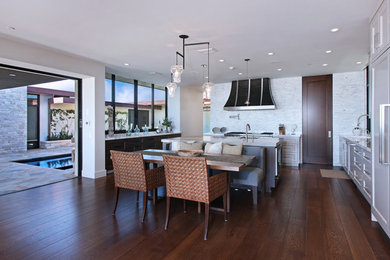 Open concept kitchen - large modern l-shaped dark wood floor open concept kitchen idea in Orange County with an undermount sink, shaker cabinets, white cabinets, marble countertops, white backsplash, matchstick tile backsplash, stainless steel appliances and an island