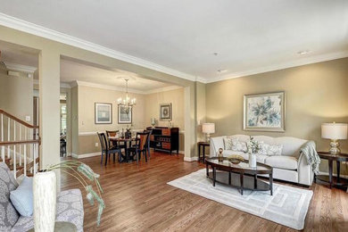 Large transitional open concept medium tone wood floor and beige floor living room photo in DC Metro with beige walls