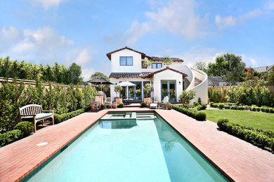 Large tuscan backyard brick and rectangular lap pool photo in Los Angeles