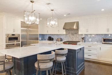 Photo of a large classic grey and white u-shaped enclosed kitchen in New York with a built-in sink, shaker cabinets, white cabinets, engineered stone countertops, grey splashback, engineered quartz splashback, stainless steel appliances, dark hardwood flooring, an island, brown floors and white worktops.