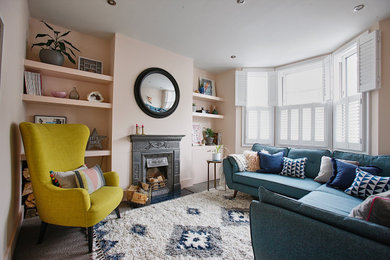 This is an example of a large bohemian formal and grey and pink open plan living room in Sussex with pink walls, carpet, a wood burning stove, no tv, grey floors, wainscoting, feature lighting and a concrete fireplace surround.